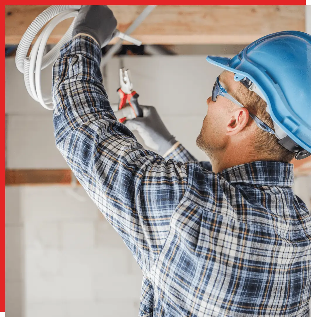 Electrician working with tools overhead.